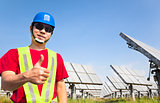 happy worker with thumb up and standing before solar panel track