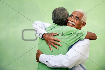 Old friends, two senior african american men meeting and hugging