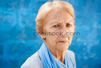 sad old blond woman looking at camera