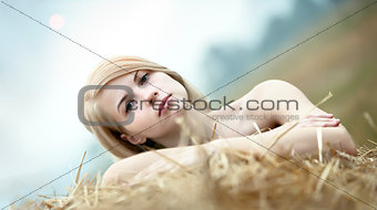 Young woman among the straw.