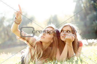 two girlfriends outdoor looking upwards