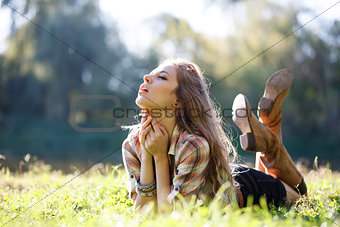 Beautiful Young Woman lying on grass with closed eyes