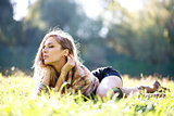 Beautiful Young Woman lying on grass with closed eyes
