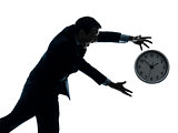 business man running after clock silhouette