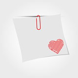 White paper note with clip and red heart.