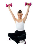 Smiling fit girl working out with dumbbells