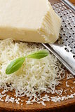 grated parmesan cheese and metal grater on wooden plate