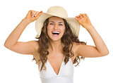 Portrait of smiling young woman in swimsuit and hat