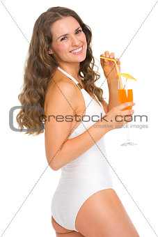 Happy young woman in swimsuit with cocktail