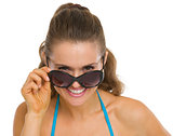 Happy young woman looking out from sunglasses