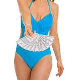 Closeup on fan of dollars in hand of young woman in swimsuit