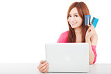 beautiful young woman holding credit card with laptop