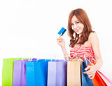beautiful young woman holding credit card with shopping bags