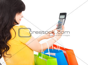 young woman holding shopping bags and calculator