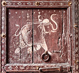 Old wooden door with a picture of an elephant. Fragment. 