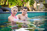 Happy young couple relaxing in a swimming pool