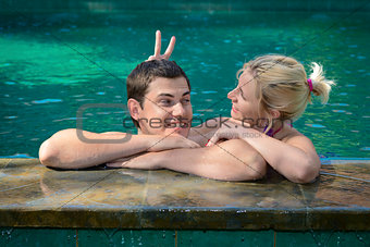 Happy playful couple relaxing in a swimming pool