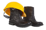 Boots and yellow hard hat over white background