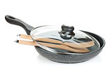 Frying pan with glass cover and wooden utensils