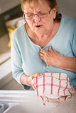 Senior Adult Woman At Sink With Chest Pains