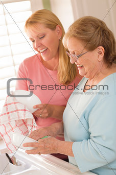 Senior Adult Woman and Young Daughter Talking in Kitchen