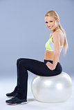 Blond sporty woman sitting on fitness ball