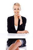 Sexy blond business woman sitting in front of desk