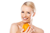 Smiling girl is holding fresh orange