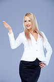 Smiling blond business woman pointing at copy space