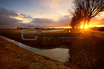 sunrise in farmland by canal