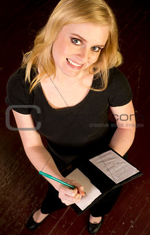 Young Attractive Female Server Writes and Order in the Restauran