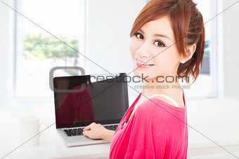 smiling young woman sitting with laptop computer 