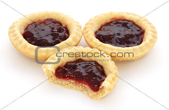 Three jam tarts, one with a bite taken