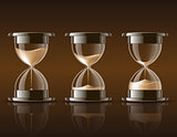 Sand falling in the hourglass in three different states on dark background.