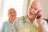 Senior Adult Husband on Cell Phone with Wife Behind