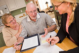 Senior Adult Couple Going Over Papers in Their Home with Agent