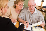 Senior Adult Couple Going Over Papers in Their Home with Agent