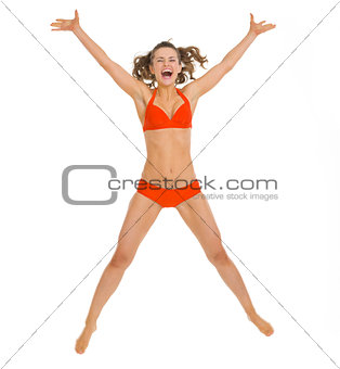 Happy young woman in swimsuit jumping