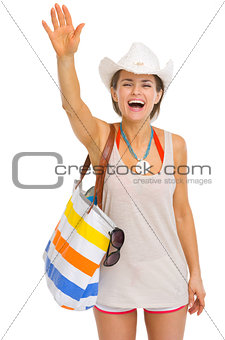 Smiling young beach woman in hat greeting