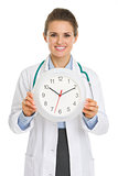 Smiling medical doctor woman showing clock