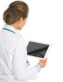 Medical doctor woman using tablet pc . rear view