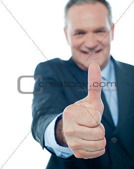 Smiling matured businessman showing thumbs-up