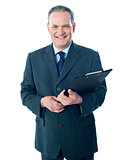 Smiling elderly businessman holding clipboard