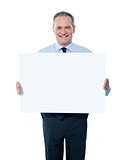 Handsome man holding blank white billboard