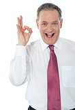 Happy satisfied businessman with okay hand sign