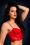 brunette woman in beautiful red lingerie on dark background