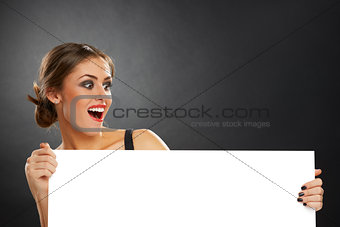 Excited woman holding blank board