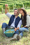 Farmer and wife sat with basket of grapes