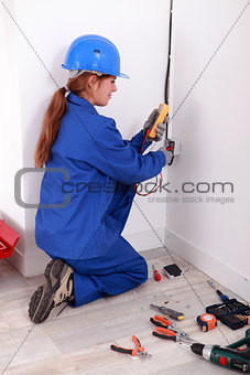 Female electrician checking socket
