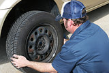 Auto Mechanic Removing Tire